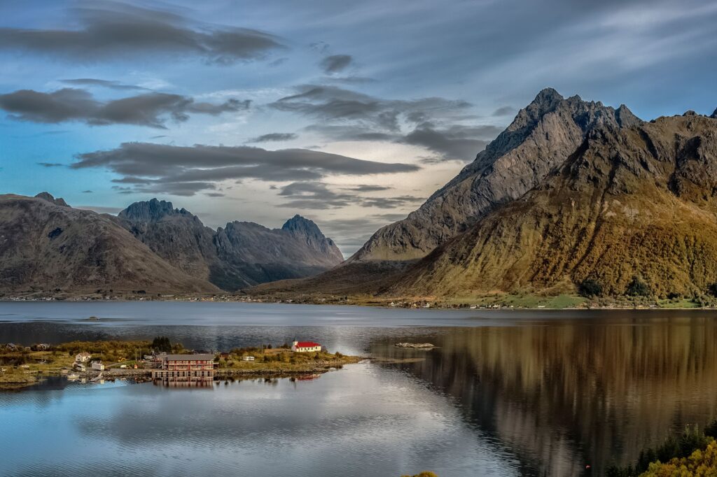 Tranquil view of Lofoten mountains reflecting in calm waters, showcasing Norway's stunning natural beauty.